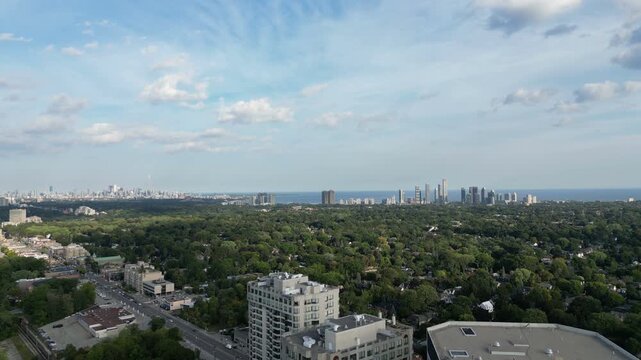 Aerial over Bloor Street West from the Kingsway Islington area of Toronto, Ontario, Canada. Flying southeast with the downtown core Toronto skyline, Mimico and Lake Ontario in the distance. 
