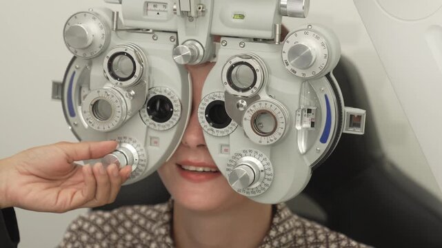 A positive female patient undergoes a professional vision check and refraction test using advanced ophthalmic equipment. This high-value commercial stock imagery represents preventative healthcare, pr