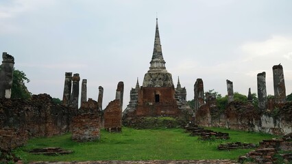 Obraz premium Ancient temple with tall spire and ruins in a grassy area