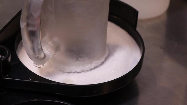 Rimming a Chilled Glass Mug with Salt for Beverage Preparation. Dipping a Glass Mug into Salt for a Perfect Rim. Close Up of Creating a Salted Rim on a Chilled Glass. Traditional Mexican Drink