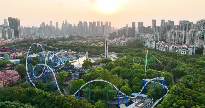 Aerial View of Amusement Park and Modern City Skyline at Sunset