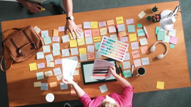 Top view of skilled businessman hand choosing color palettes while designing logo graphic. Aerial view of smart interior designer design and select color theme by using color palettes. Symposium.