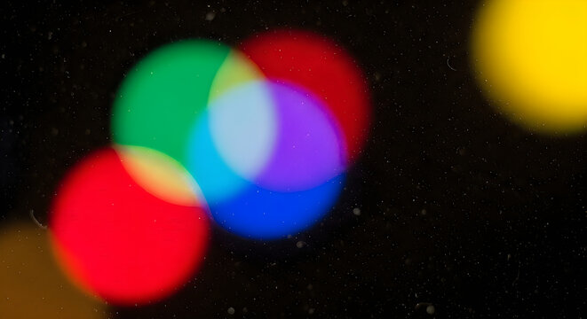 Colorful bokeh lights on a dark background with raindrops
