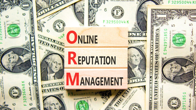 ORM online reputation management symbol. Concept words ORM online reputation management on beautiful wooden blocks. Dollar bills. Beautiful dollar bills background. Business ORM concept. Copy space.
