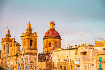 Obraz premium Spectacular view of the moored sailing yachts in seaport Vittoriosa and St. Lawrence's Catholic Church. Location place Birgu harbour, Malta, Europe. Photo wallpapers. Discovery the beauty of earth.