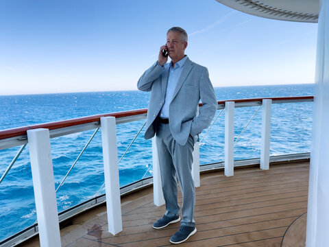 Mature business man looking forward while listening phone call during a business pleasure trip