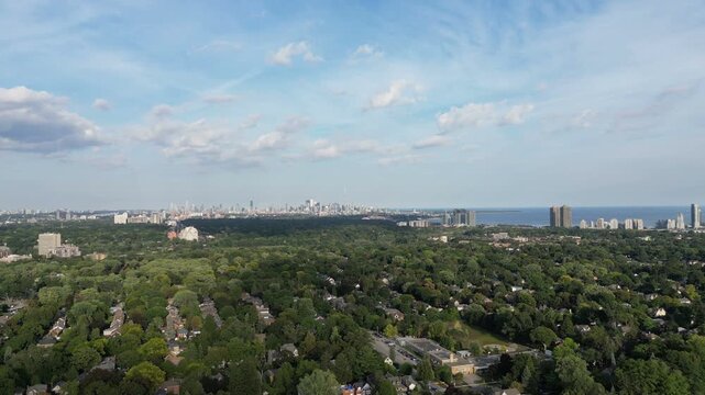 Aerial moving back over the Bloor Street West, Kingsway area of Toronto, Ontario, Canada. Downtown core Toronto skyline, Mimico and Lake Ontario in the distance. 