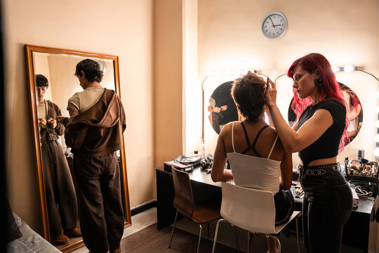 Makeup artist prepares model backstage for fashion shoot