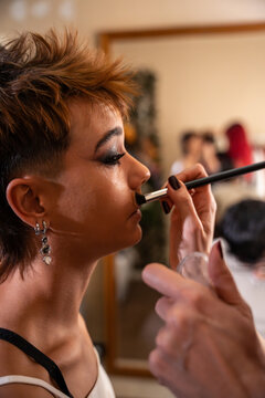Makeup artist applying powder on model during photoshoot