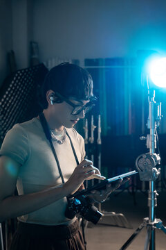 Photographer reviewing images on tablet in studio light setup
