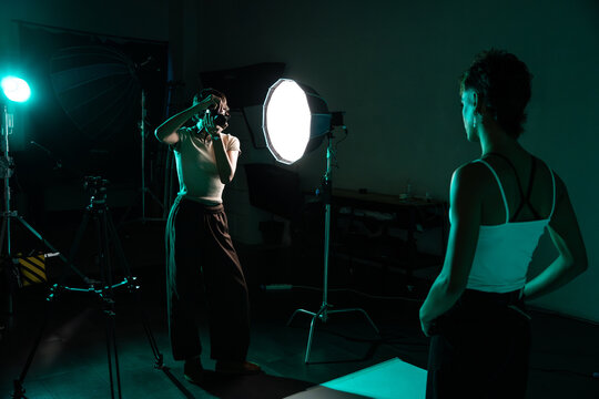 Photographer directing model during studio portrait shoot