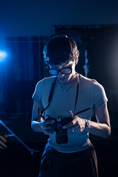 Photographer reviewing camera settings in moody studio light
