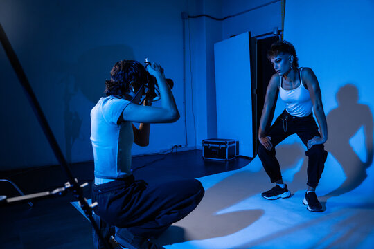 Photographer directing model during studio portrait session
