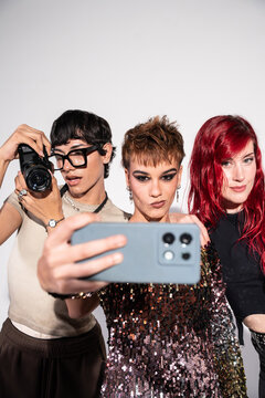 Fashion photoshoot crew taking selfie with smartphone