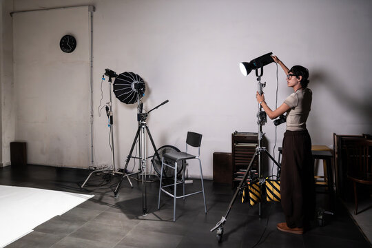 Fashion photoshoot crew adjusting studio light equipment