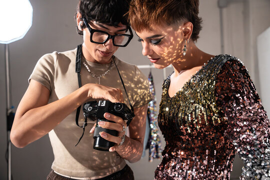 Fashion photoshoot team reviewing camera images in studio