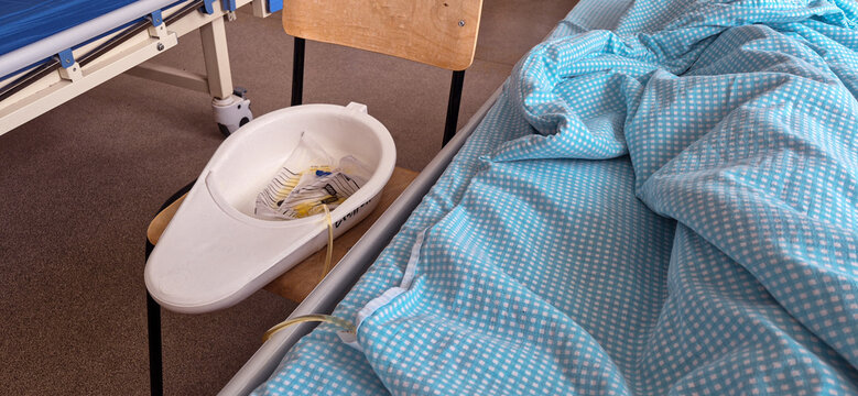 a vessel with a macha and a tube at the patient's bedside in a hospital ward