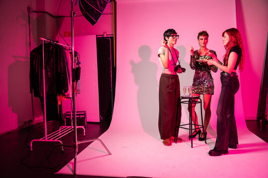 Fashion photoshoot crew celebrating in studio with drinks