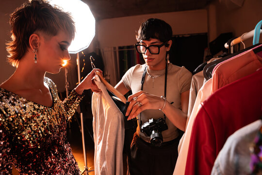 Photographer and model select outfits in studio wardrobe