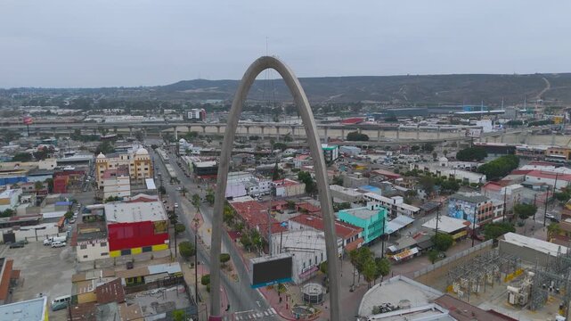 Aerial Dusk Flight of Main Avenue and Monumental Arch Near US-Mexico Border in Tijuana, Mexico.