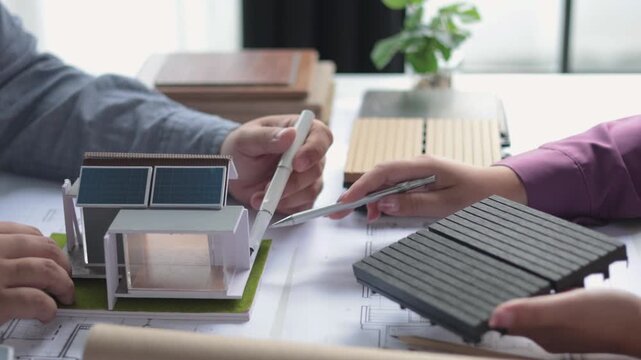 Architect and interior designer collaborating on floor plans and flooring material samples.