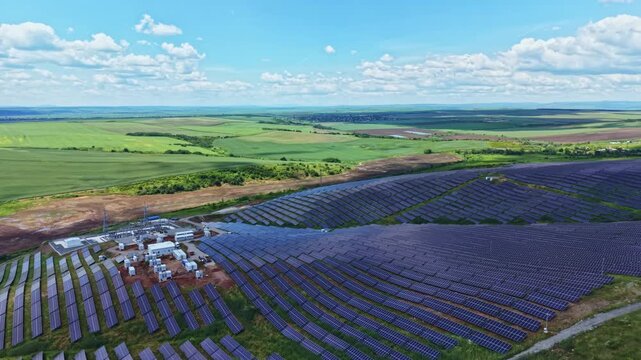 Aerial lavender plantation during harvest staging, expansive purple rows with clusters of crates and vehicles, distant green horizon under scattered clouds,