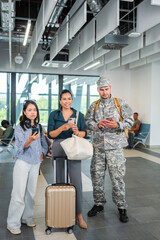 Fototapeta premium Diverse people traveling, looking at smartphones in airport