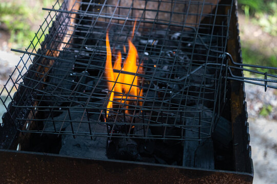 Charcoal flame beneath wire grilling basket