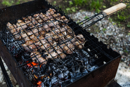 Grilled meat in charcoal wire basket