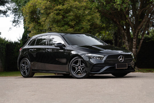 Black Mercedes A200 front three quarters view outdoors, Luxury hatchback parked near trees