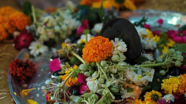 Sacred Shiva Lingam Decorated with Flowers During Temple Worship