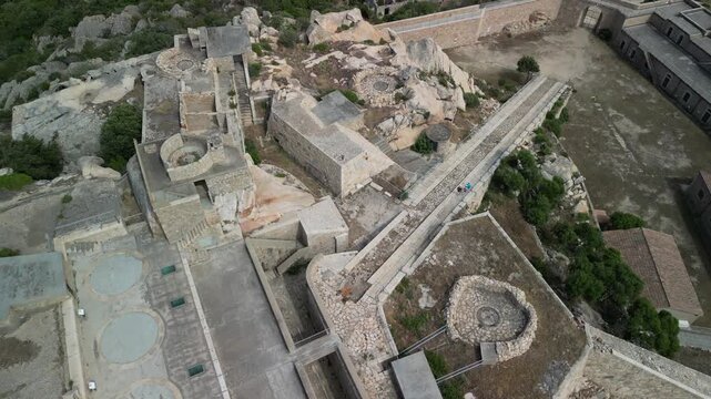 Sardynia - Włochy
Fortezza di Monte Altura forteca starożytna na szczycie g&oacute;ry. Ładne ujęcie nagrane dronem z pięknymi widokami na fortece, morze, g&oacute;ry