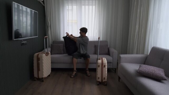 Digital nomad lifestyle and remote work mobility. Man arriving in temporary apartment, working immediately and continuing journey