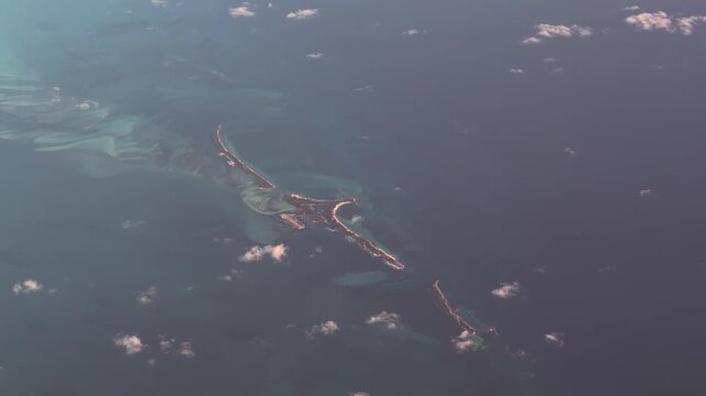 4k aerial video footage flying across the Bimini chain of The Bahamas, with North Cat Cay, South Cat Cay and Gun Cay surrounded by shallow turquoise water surface, located in the Caribbean Sea 