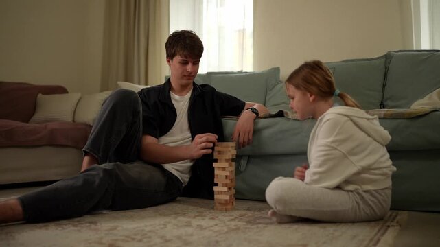 Kids stack blocks together on the floor while a dog observes them closely during playtime at home