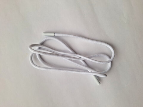 A single white shoelace with plastic aglets isolated on white background