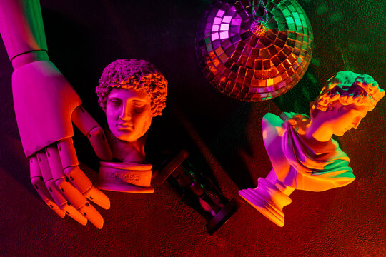 Classical sculpture busts with disco ball and neon lighting for contemporary pop art concept