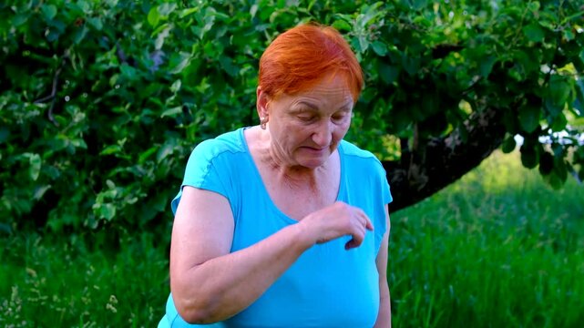 sudden sneeze interrupts a peaceful moment in garden grandmother wipes and rubs nose. scene illustrates pollen sensitivity seasonal allergies respiratory irritation and everyday health concerns.