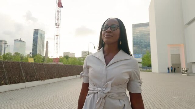 Elegant woman wearing glasses smiling in the city center
