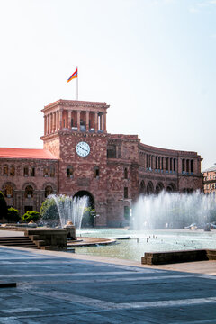 Government House of Armenia with clock tower, Armenian flag and fountains on Republic Square in Yerevan, Armenia
