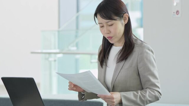 資料を見ながら悩む女性