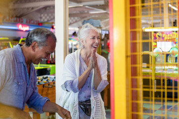 Obraz premium Joyful seniors enjoying arcade games