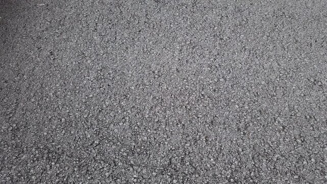Road construction. Fresh layer of asphalt. Rainy weather. Abstract close up shot