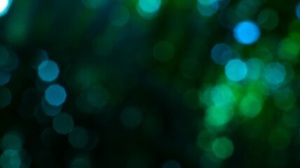 Abstract blurry bokeh lights in dark green and blue hues creating a dreamy background suitable for © M Halim Abduh