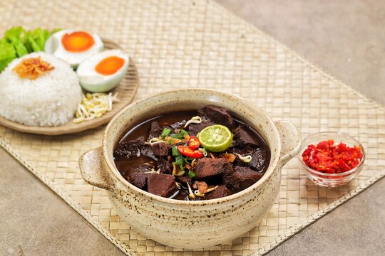 Rawon, a rich black beef soup from East Java made with tender beef and keluak nuts, served with steamed rice, bean sprouts, salted egg, and sambal