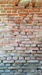 Naklejka premium Exterior view of a decaying historical brick structure showing aged masonry, spalling blocks, and natural weathering over time