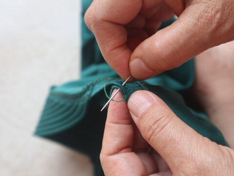 Woman hands sewing on fabric