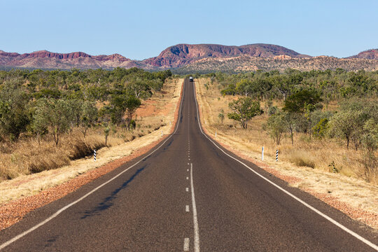 The car and caravavan on the road to Lake Argile in the Kimberely region with the Carr Boyd Ranges in the background .