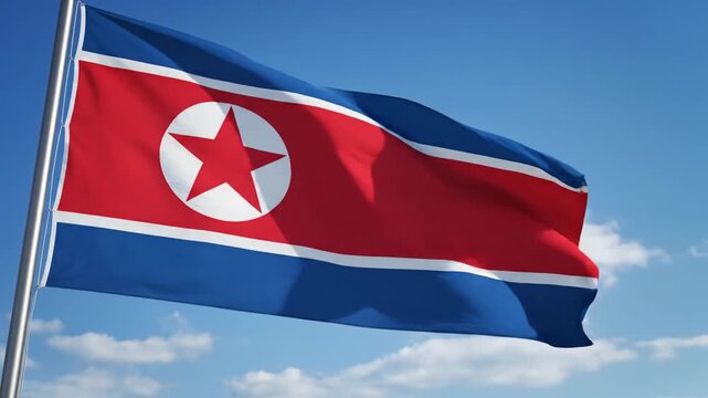 National flag of North Korea waving against blue sky.