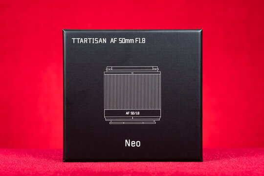 ZHONGSHAN China-May 30 2026: Square black rigid packaging box of TTArtisan AF 50mm F1.8 Neo camera prime lens with white line art sketch.